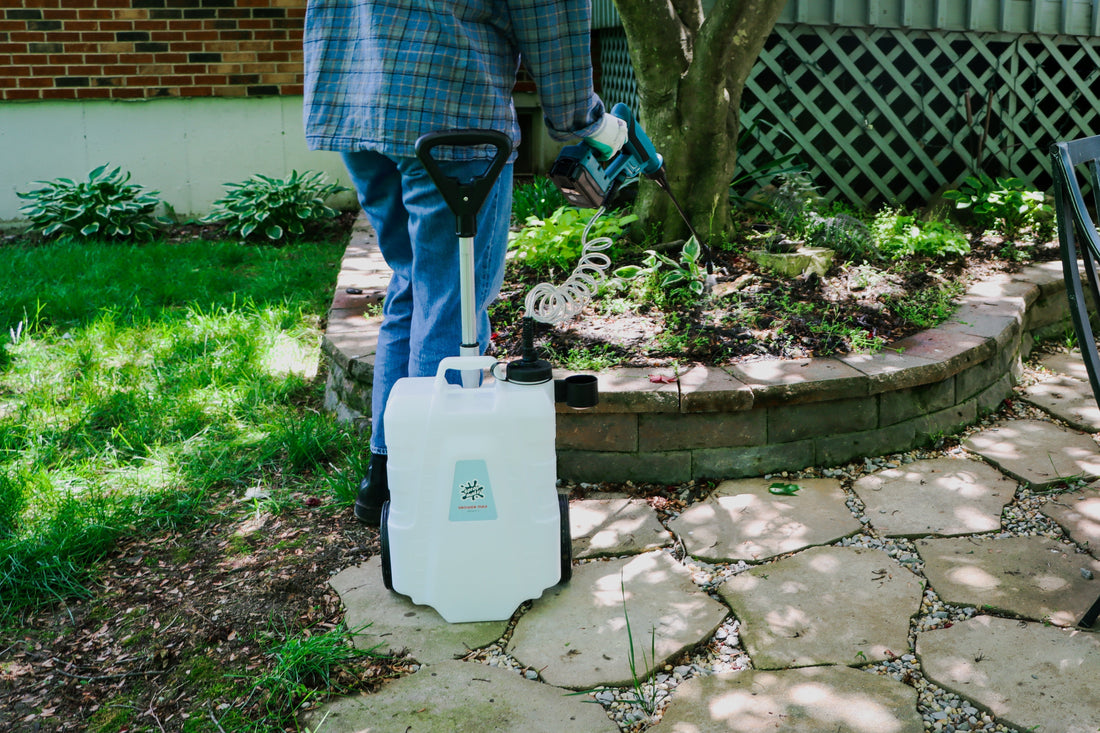 rolling battery sprayer spraying into garden bed