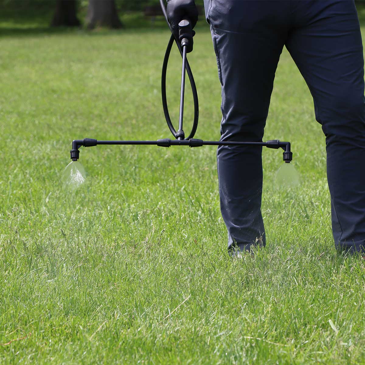 Boom nozzles spraying water on a grassy lawn area