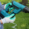 gloved hands holding battery powered spray gun